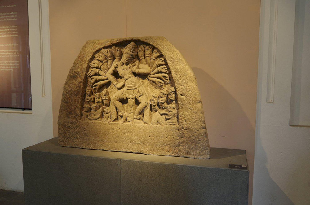A multi-armed deity in dynamic form, an iconic Cham sandstone relief from the 10th century